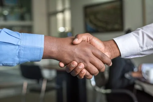 A handshake symbolizes a successful business deal and collaboration in creative arts.