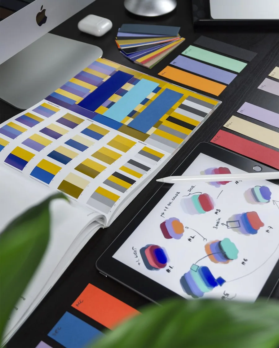 A designer's workspace with color swatches, a tablet and laptop showcases creative arts.