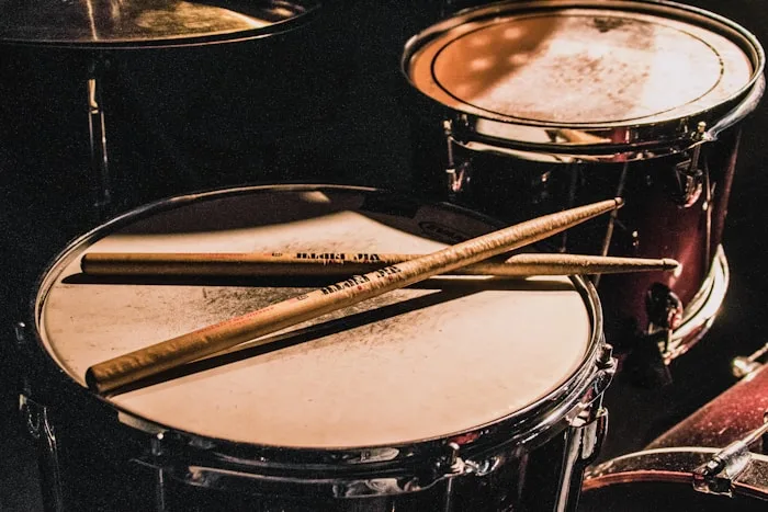 A drum set with sticks resting on the snare, showcasing percussion instruments for performing arts training.