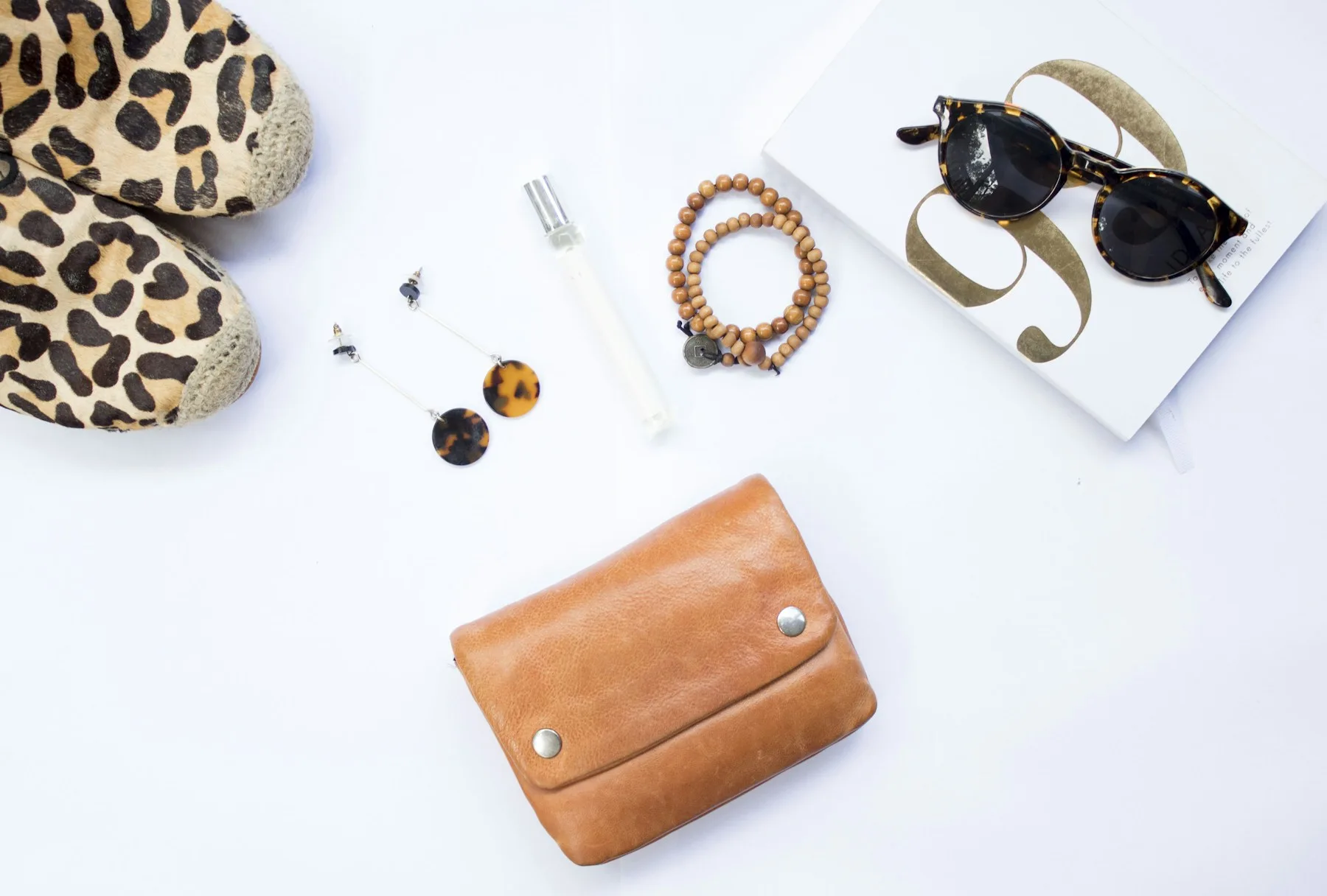 A flat lay displays fashion accessories like sunglasses and jewelry, showcasing creative arts styling.