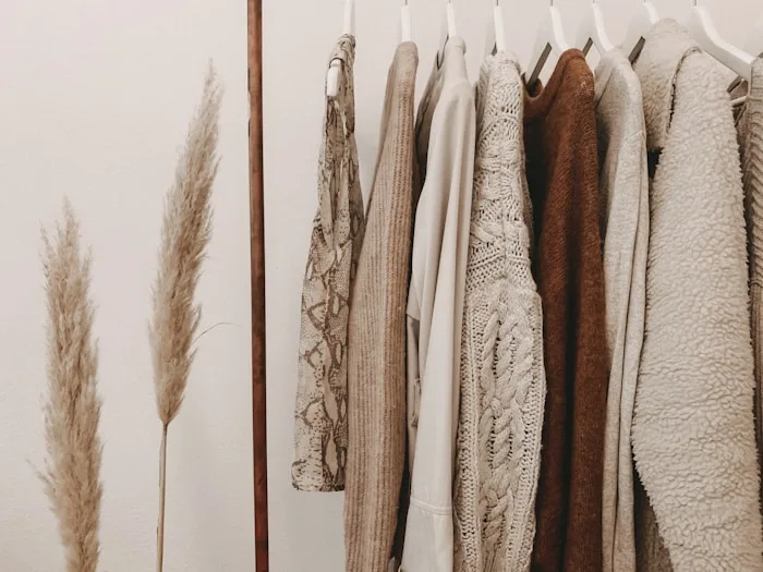 Neutral sweaters and pampas grass showcase fashion design services at CAQA Creative.