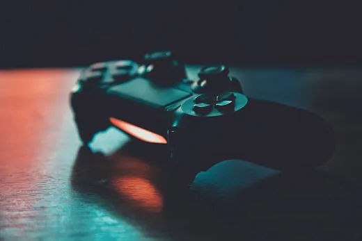 A black gaming controller sits with vibrant rgb lights, showcasing digital art services.